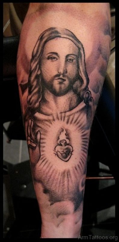 Black Ink Heart With Jesus Tattoo On Arm