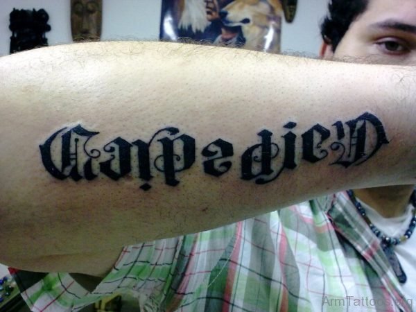 Black Inked Carpe Diem Tattoo On Arm 