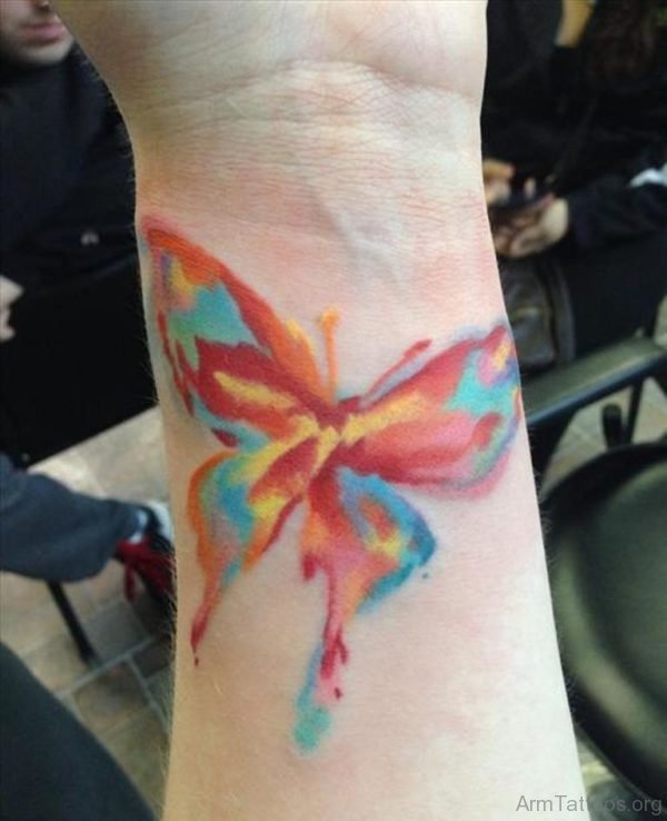Colorful watercolor butterfly tattoo on arm